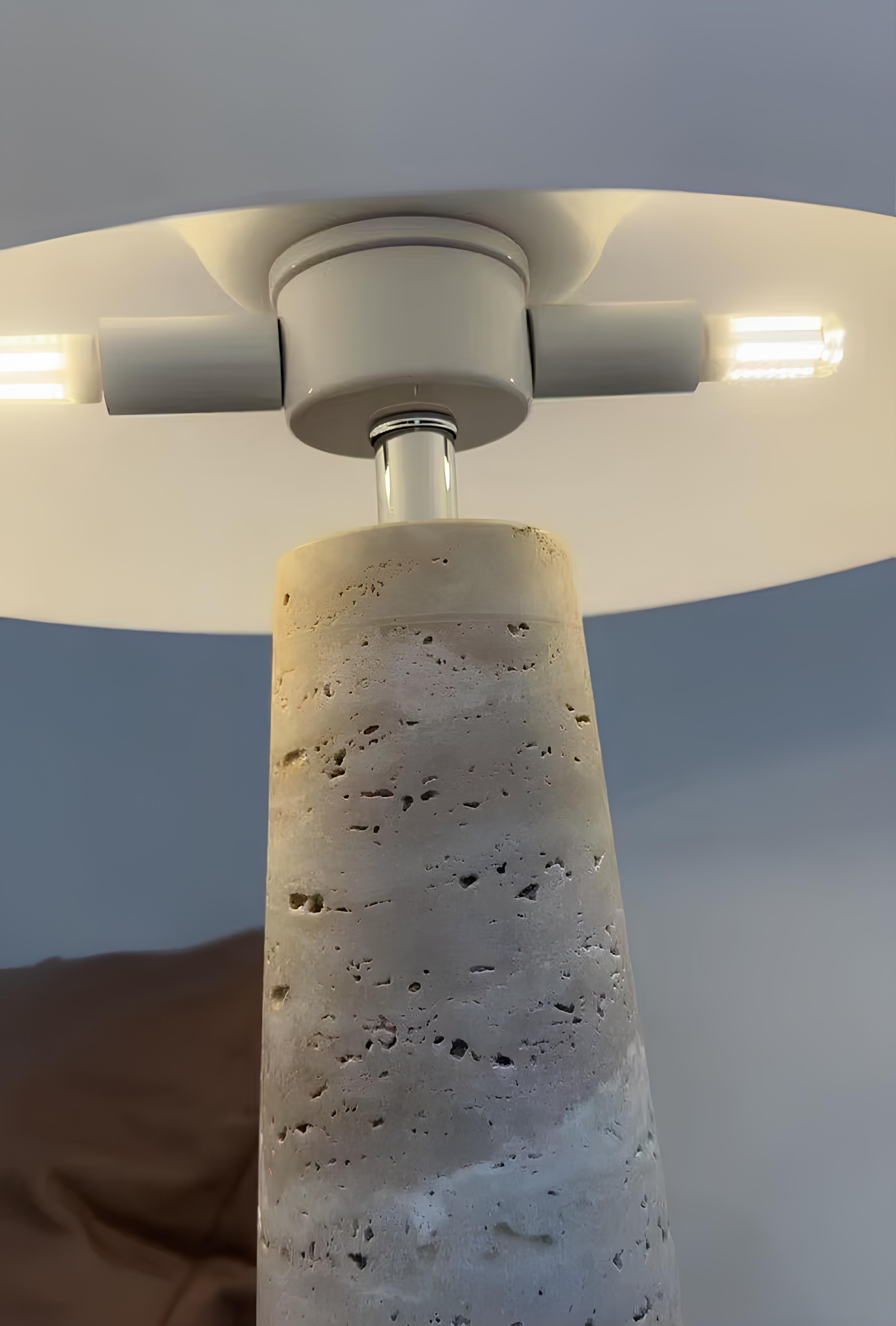 Close-up of travertine texture and soft glowing lamp