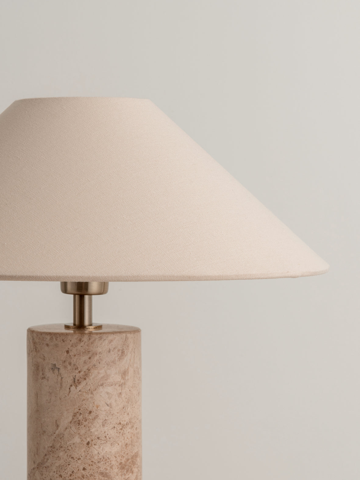 Nordic-inspired lamp with travertine base and rice-colored shade